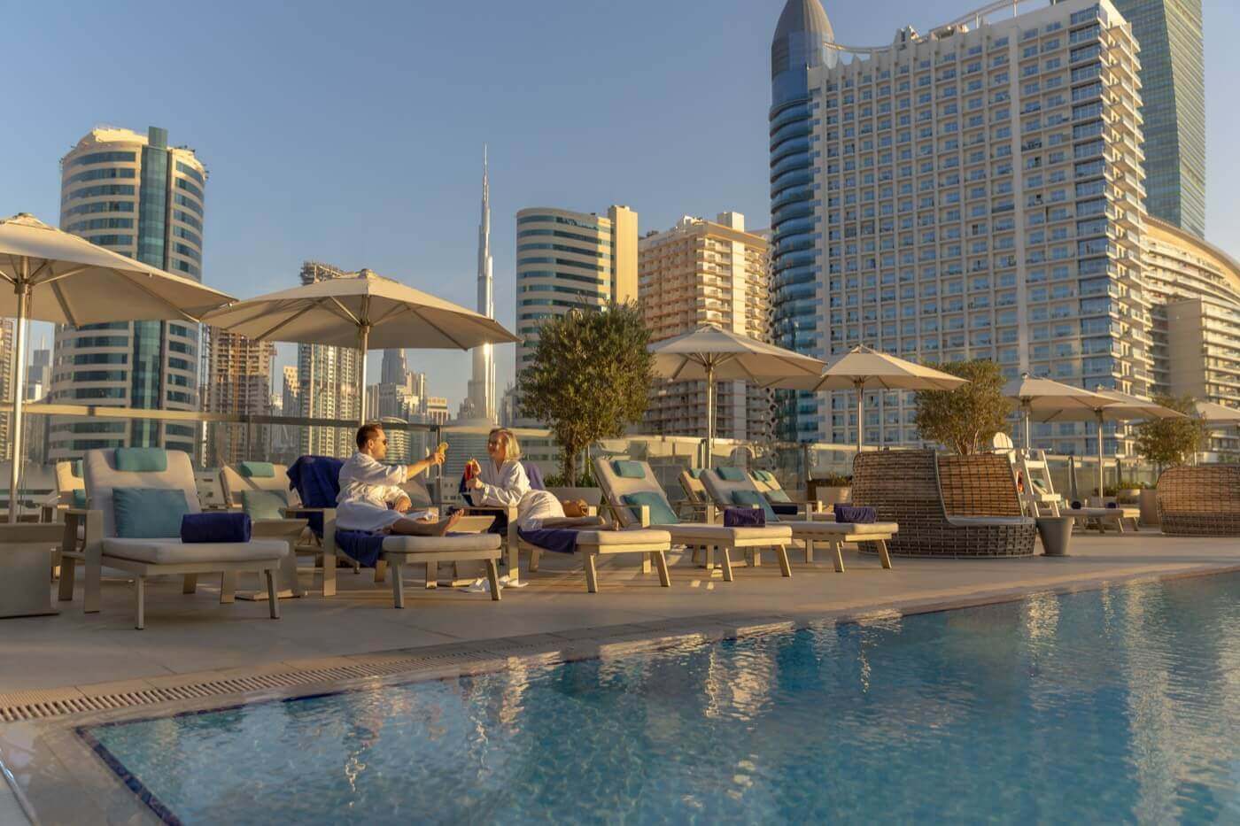 Guests relaxing by a rooftop pool in Business Bay