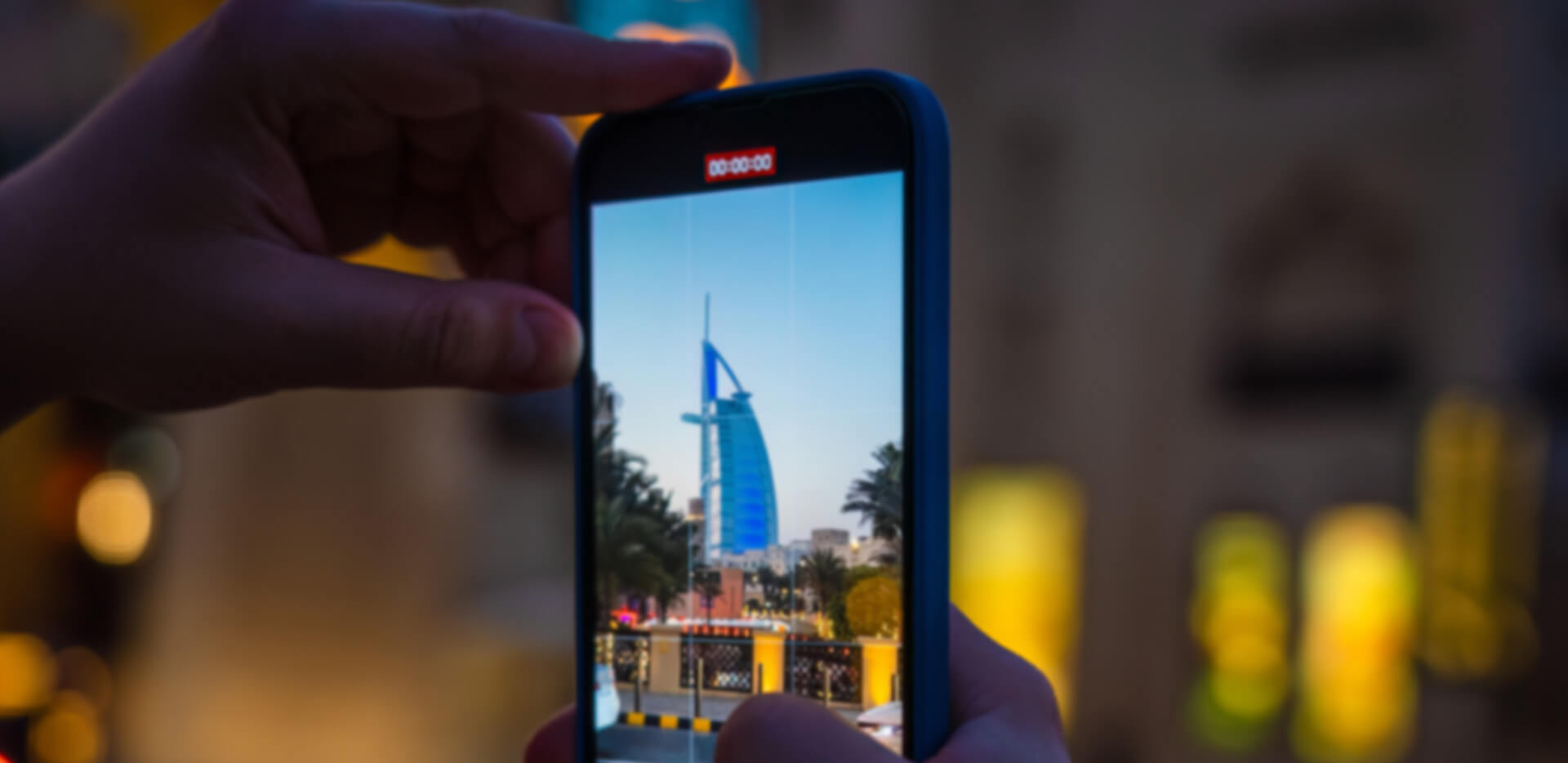Traveller photographing the Burj Al Arab on a phone